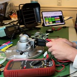 A student using tools to build a circuit board.