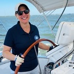 Claudine steering a boat.