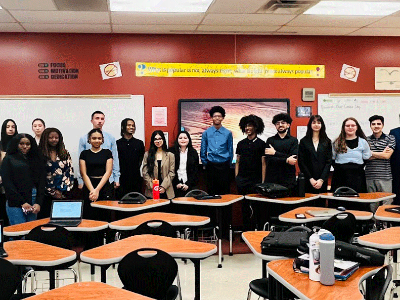 Large group of students smiling in a classroom.