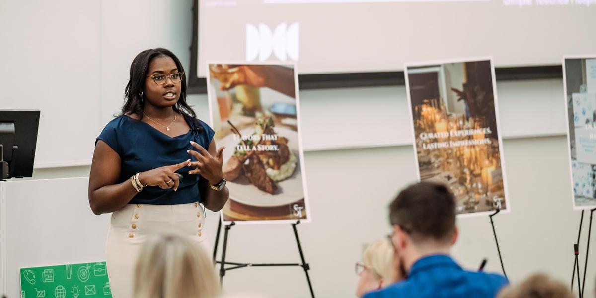 A student presents their business idea in front of a group of people.