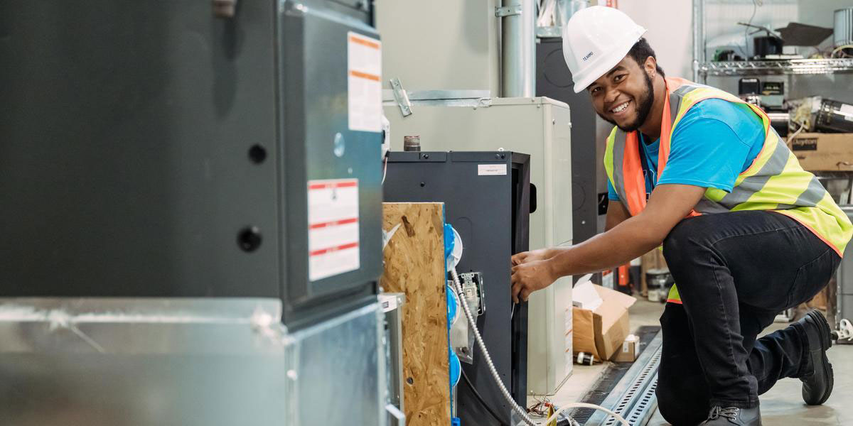 An AACC student wearing a hardhat and working on an interior system.