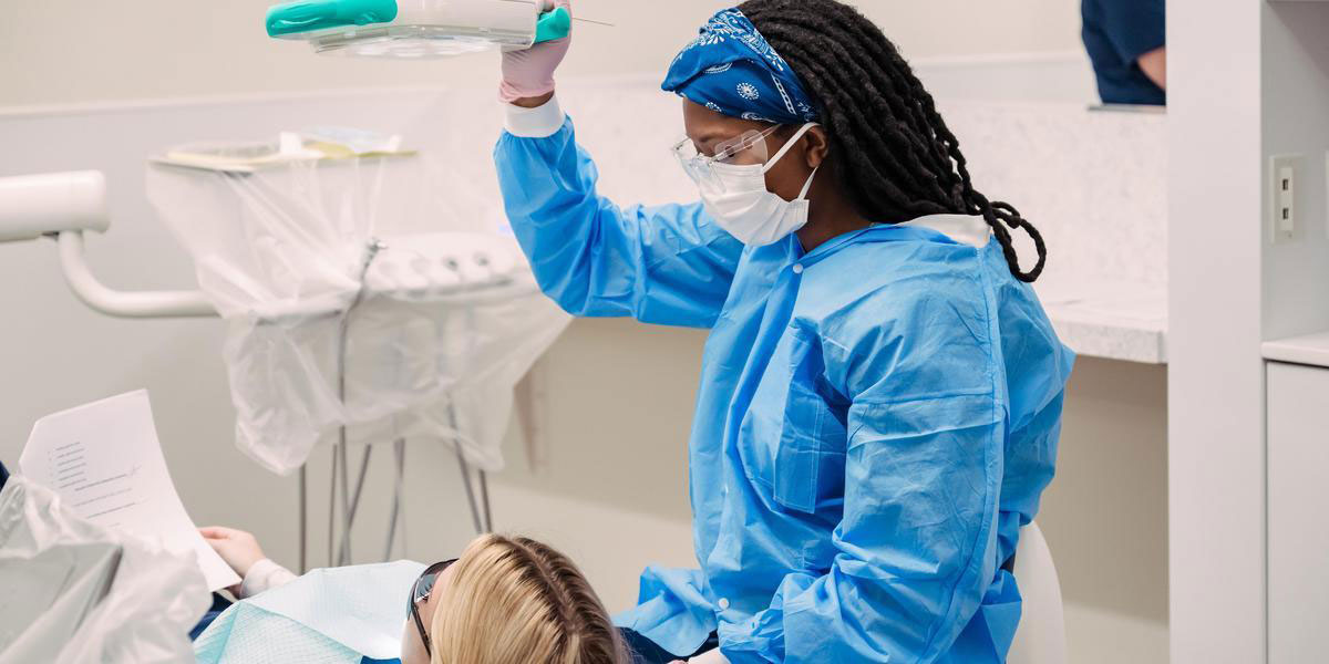 Student in a dental hygiene clinical with another student.