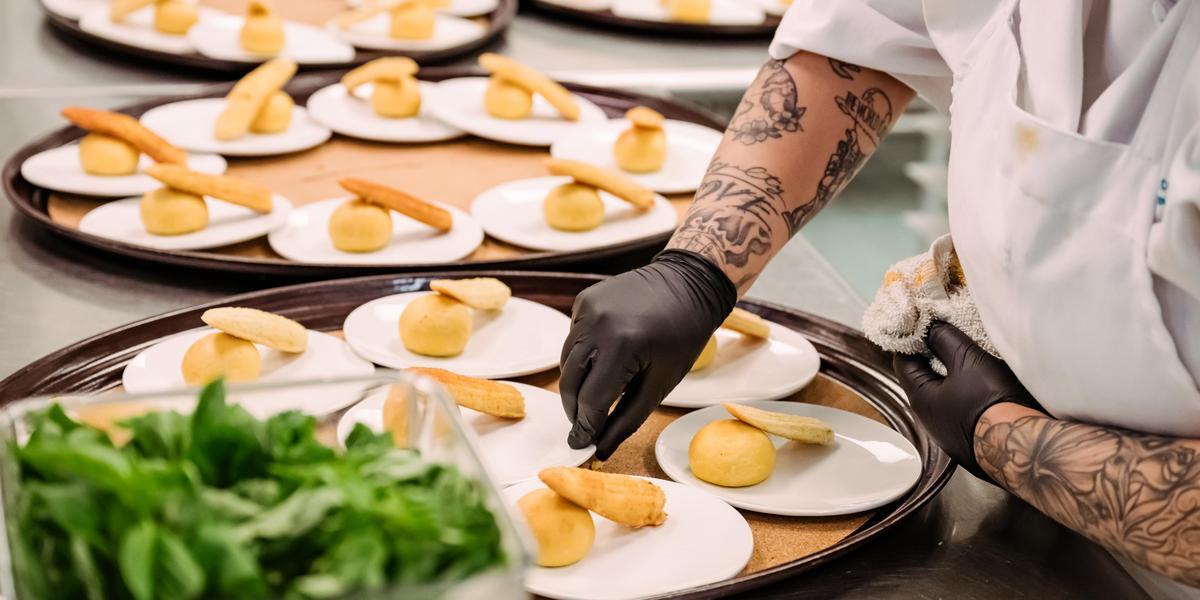 Hands putting seasoning on food