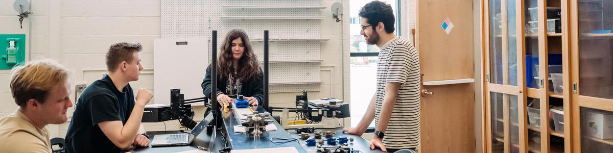 Students and professor working together in a lab.