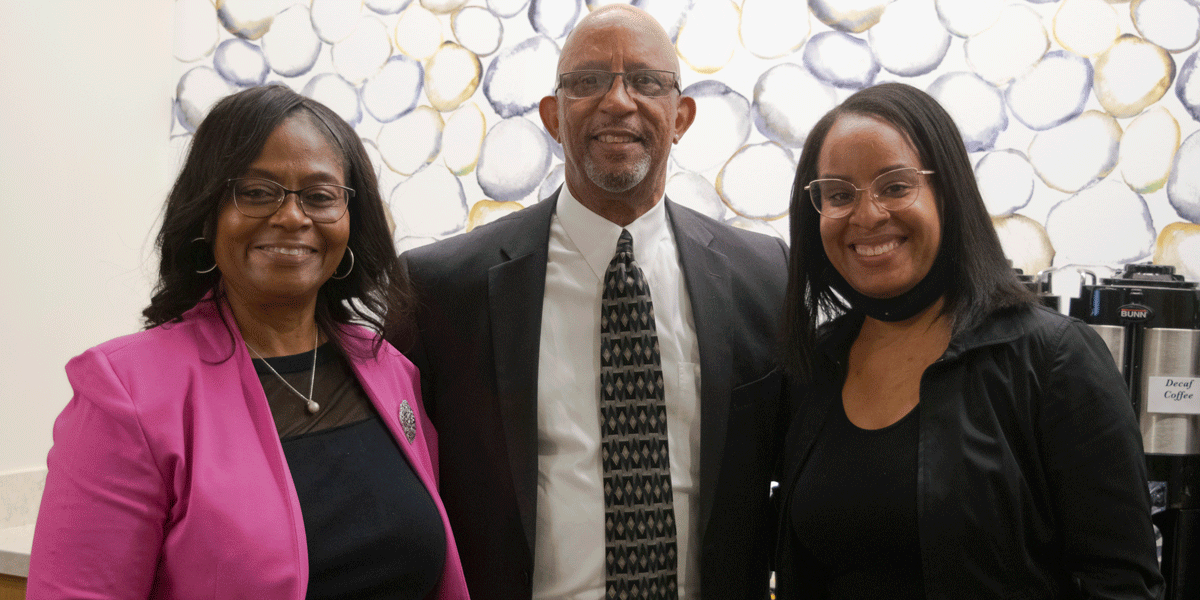 AACC employees smiling and posing inside a room.