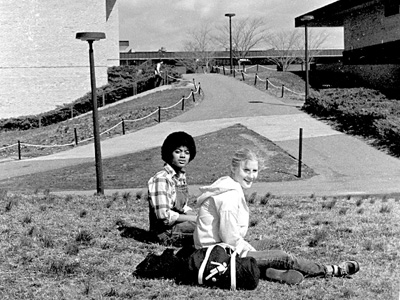 Students sitting in grass on campus.