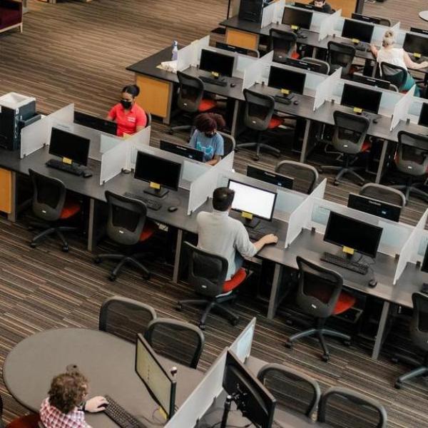 AACC students on computers inside library.
