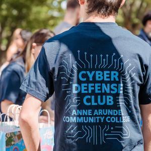 Student wearing a T-shirt for the Cyber Defense Club at AACC.